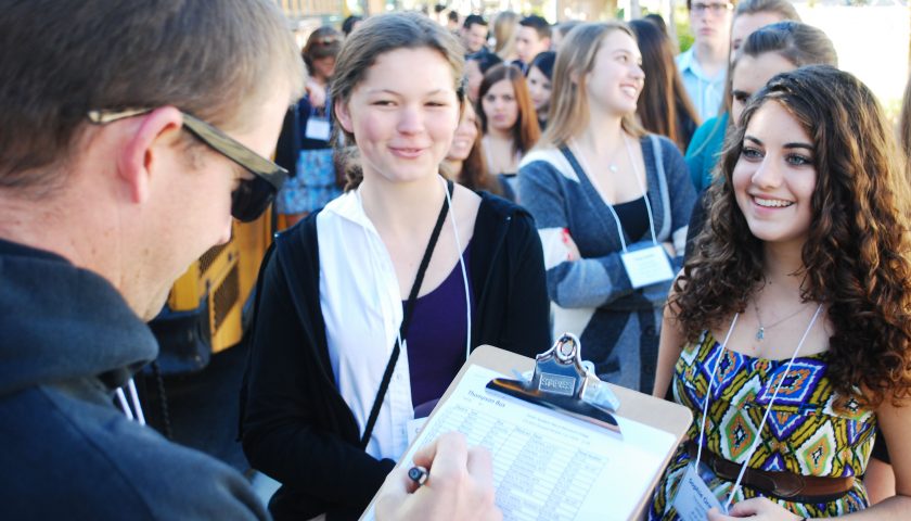 checking in—EThOS teacher Ryan Thompson checks off sophomores Caroline Paules and Sophie Ormond before they board the bus to Moorpark College. 