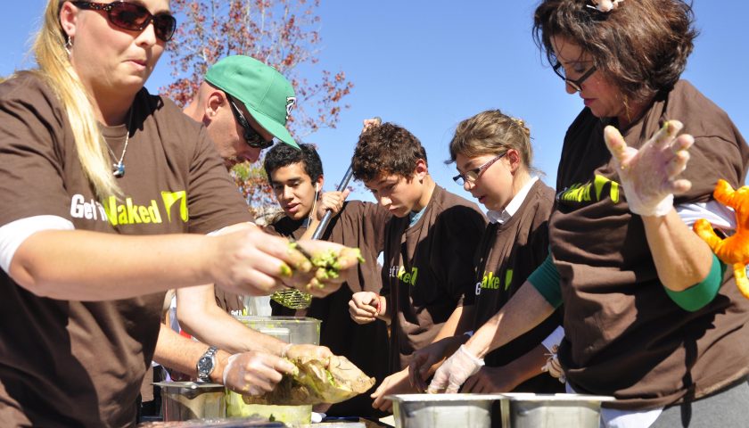 SQUASH THE GUAC—Freshman Gabriel Caro helps his team make guacamole in Red Ribbon  Week’s “smash  guacamole not cars, the text can wait.” The event featured a smashed car and was sponsored by Sharky’s Woodfired Mexican Grill.