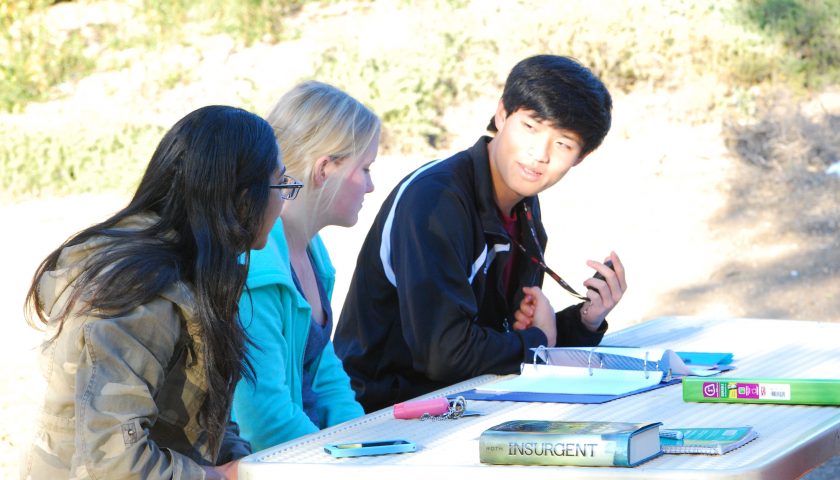 BRAINSTORM—At a recent meeting at Redwood Middle School, (from left to right) junior Sarah Ayyad and seniors Christy Macleod and Noah Chow help improve a student’s Ventura County Science Fair project.