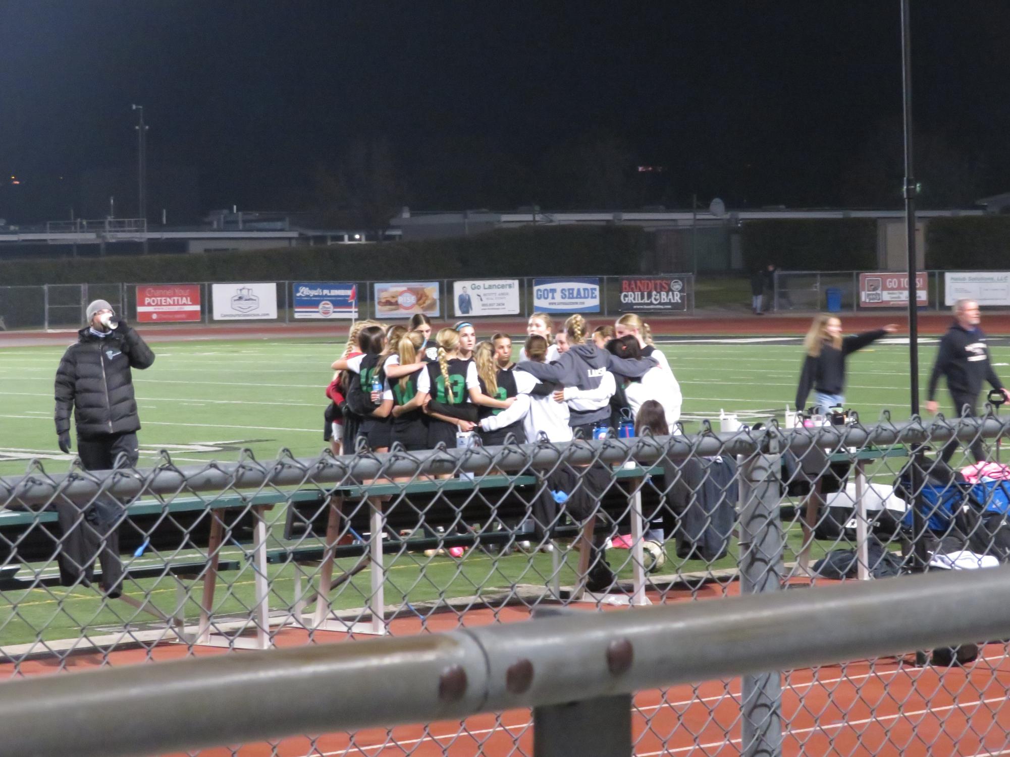 The soccer teams huddles up, ready for some game-winning plays